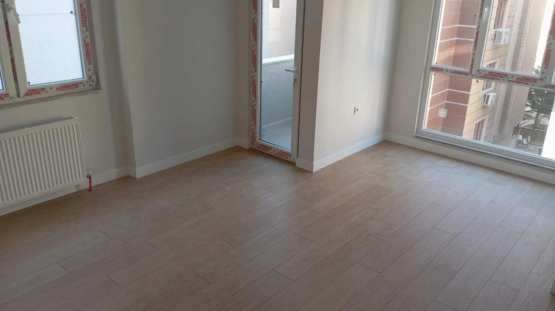 Uzun antre zemininde doğrusal eksende döşenmiş ahşap desenli laminat parkeler